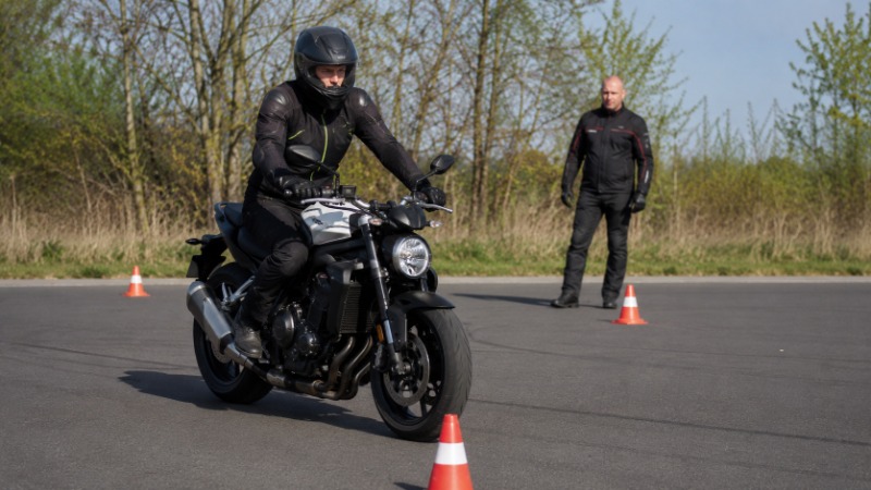 Detail ruky motorkáře na brzdové páčce těsně před zpomalením v provozu