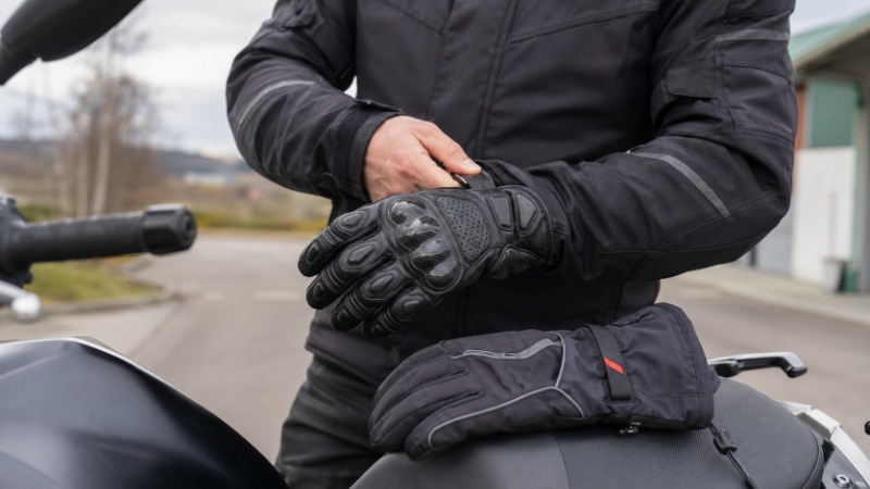 Motorkářské rukavice různých typů srovnané vedle sebe, letní kožené i zimní textilní s chrániči kloubů